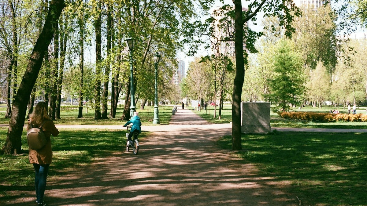 man in blue jacket riding bicycle on park during daytime